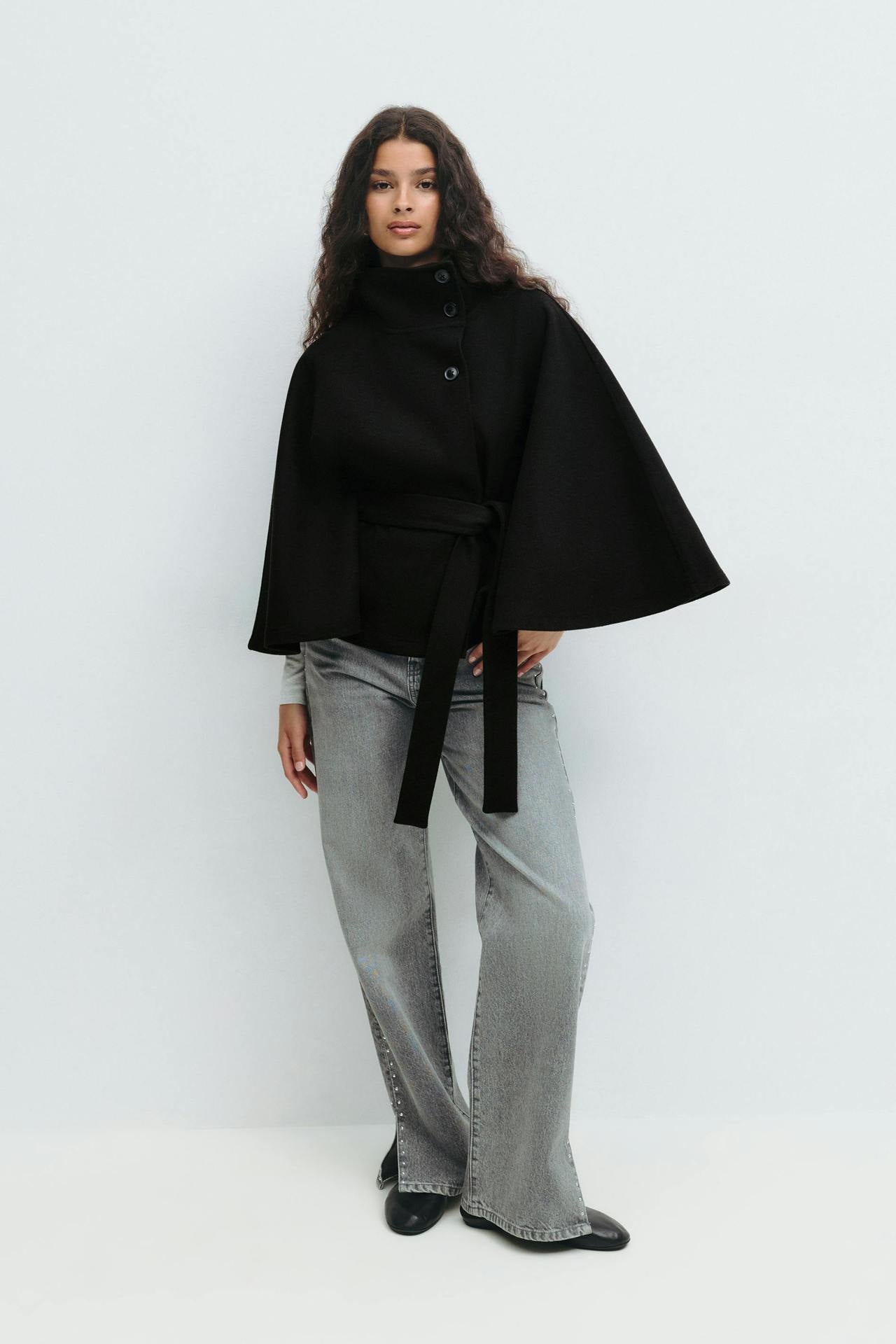 Margo & Main – Anneke black button-front belted cape coat, full-length front view with grey wide-leg jeans, US women's sizes