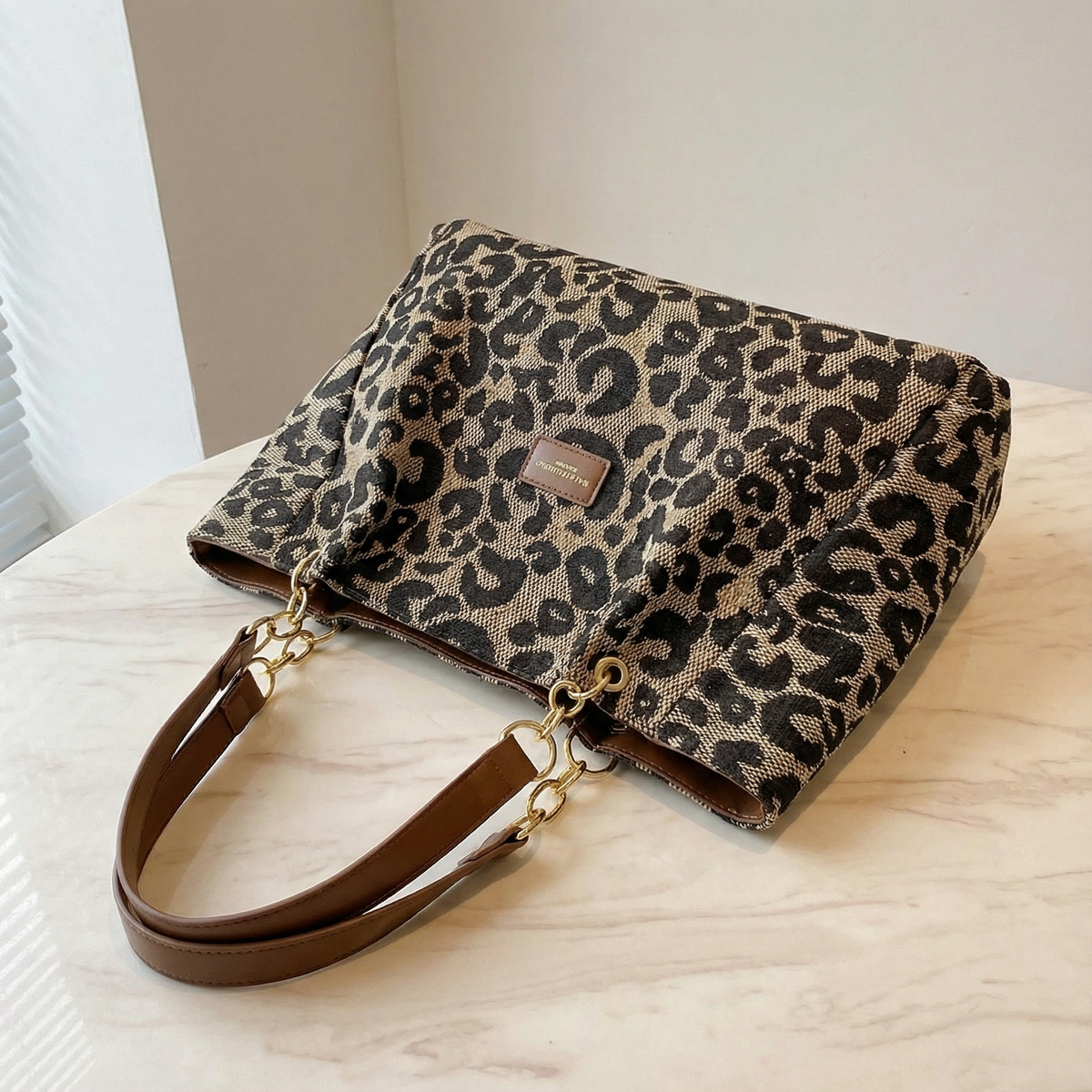 Margo & Main – Lynxe brown leopard canvas bag on a table, showing the chain and handles