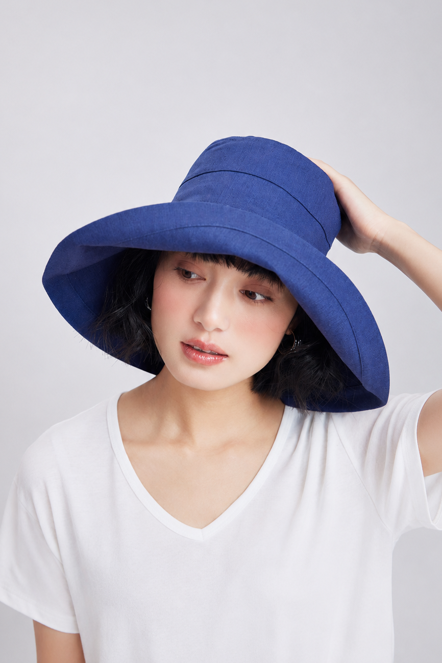 Margo & Main – Elke navy wide-brim foldable bucket sun hat, front view with the brim lifted away from the face
