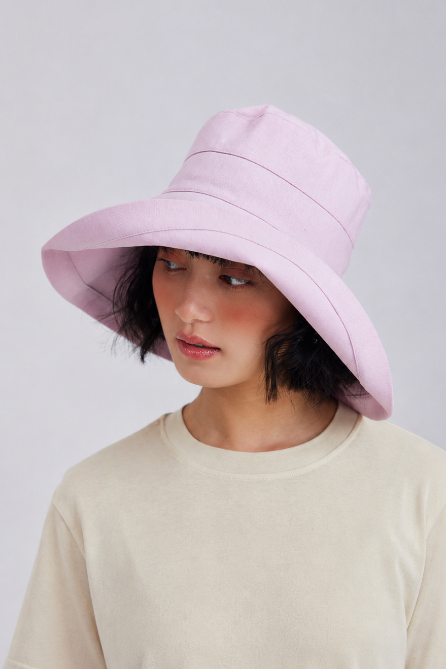 Margo & Main – Elke pink wide-brim sun hat tilted down over the eyes, three-quarter view on model