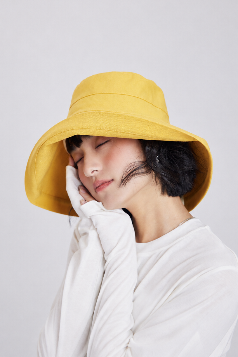 Margo & Main – Elke yellow bucket sun hat with a wide downward brim, front view on model, UPF 50+ handmade foldable style