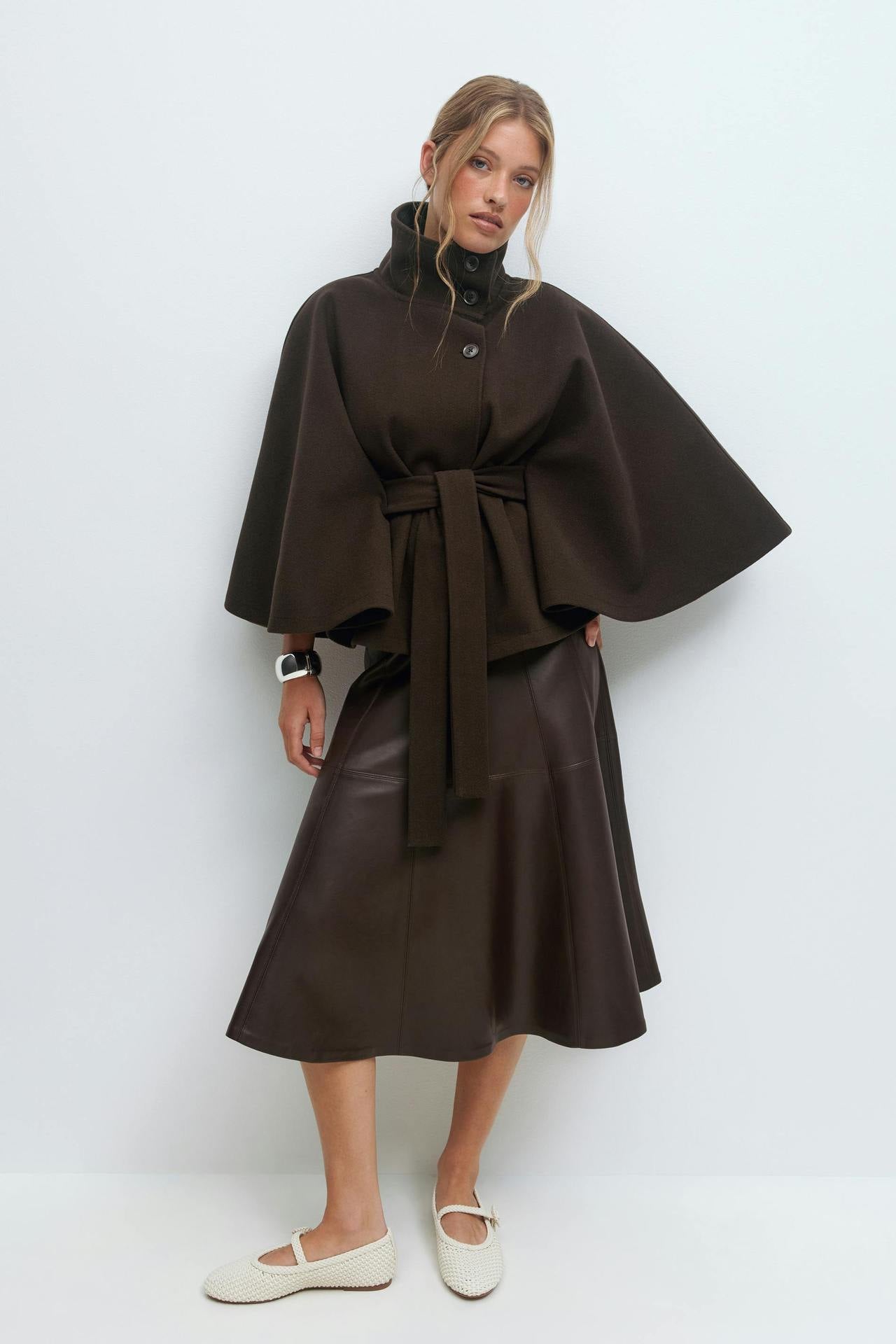 Margo & Main – Anneke chocolate brown button-front belted cape coat, full-length view styled over a leather midi skirt, US women's sizes