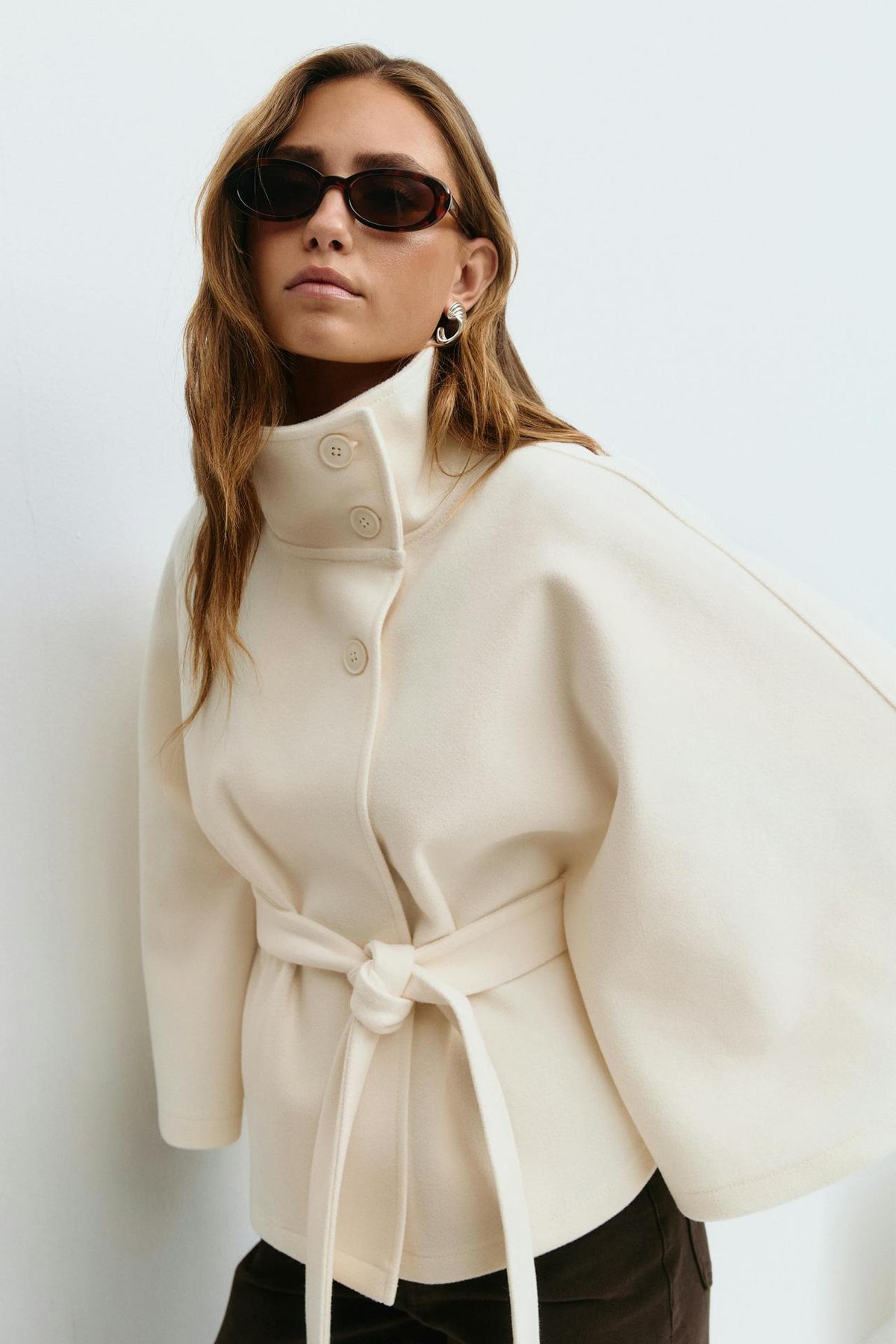 Margo & Main – Anneke ivory button-front belted cape coat, waist-up front view with the knotted belt, US women's sizes