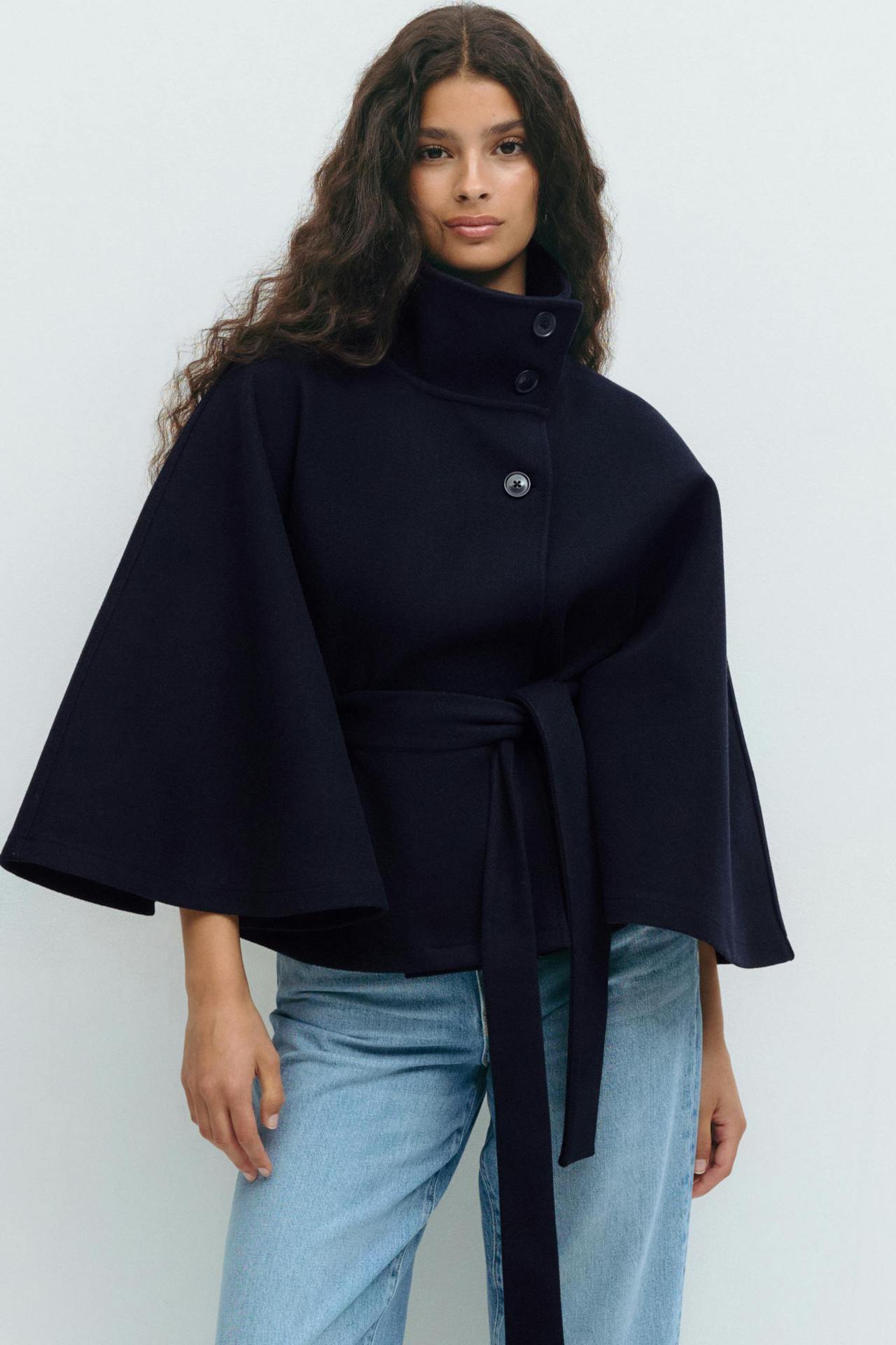 Margo & Main – Anneke navy button-front belted cape coat, waist-up front view with light blue jeans, US women's sizes