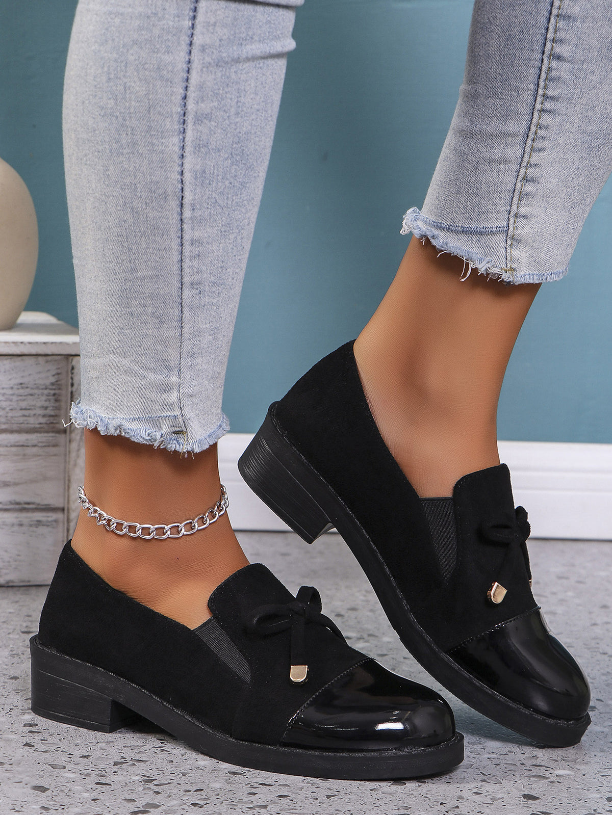Margo & Main black bow patent cap-toe block heel loafers — worn view of the bow and patent toe