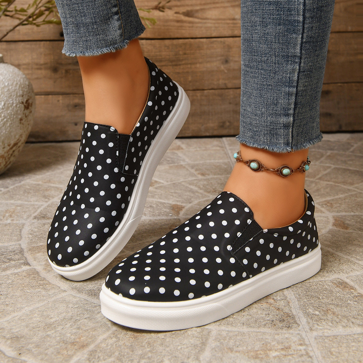 Margo & Main black polka dot platform slip-on loafers — worn front view with white platform soles
