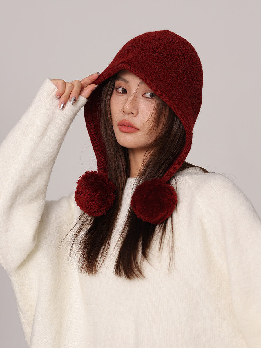 Margo & Main red wool pom pom hood — side view with the pom pom ties falling forward