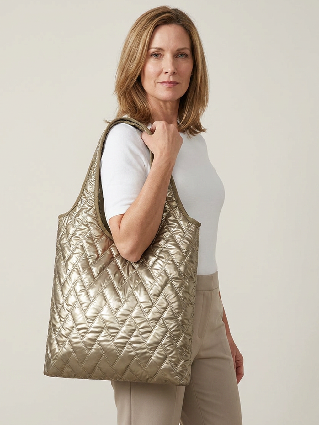 Mila Puffer Tote Bag in Gold carried by a confident woman in a clean studio setting.